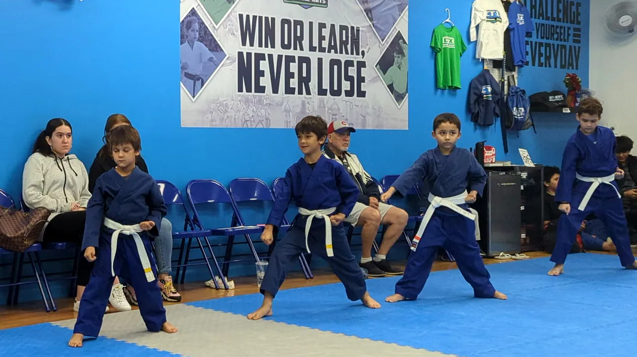 Children practicing a basic karate stance in their class
