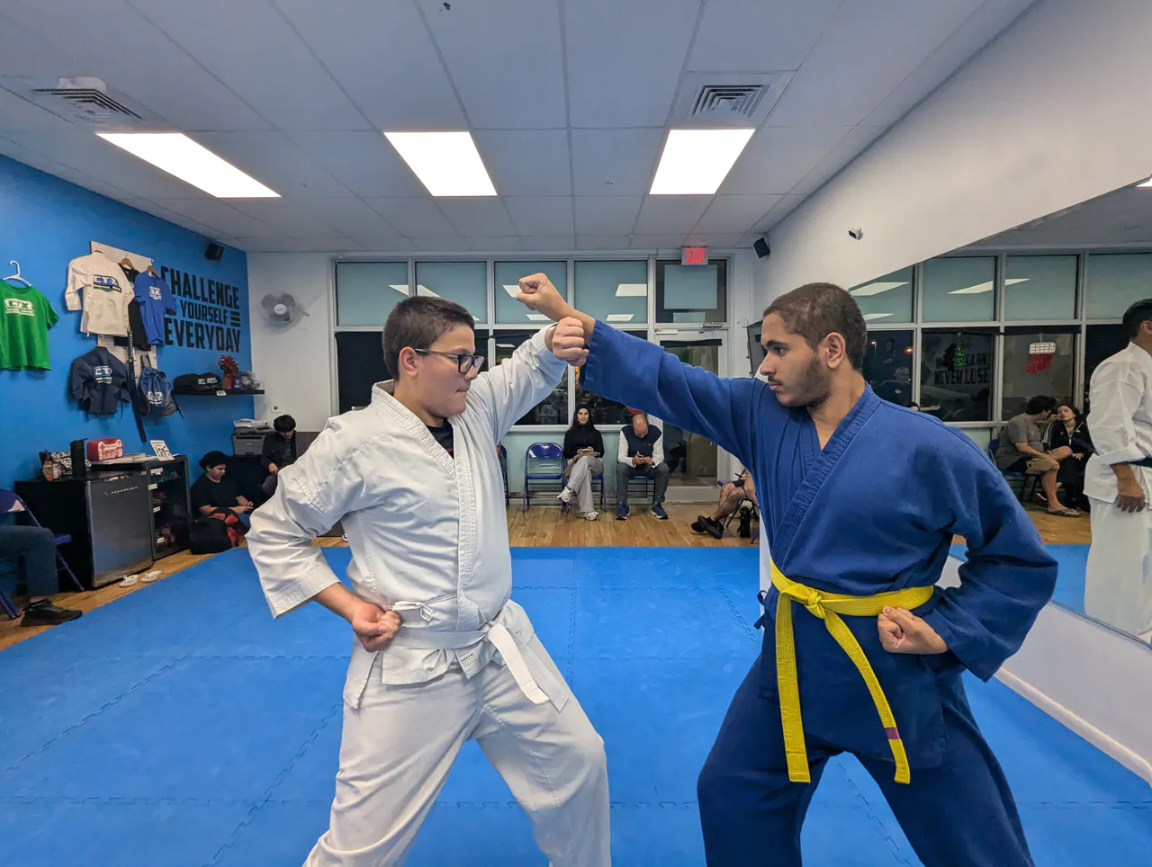 Instructor coaching a child through a self-defense block drill