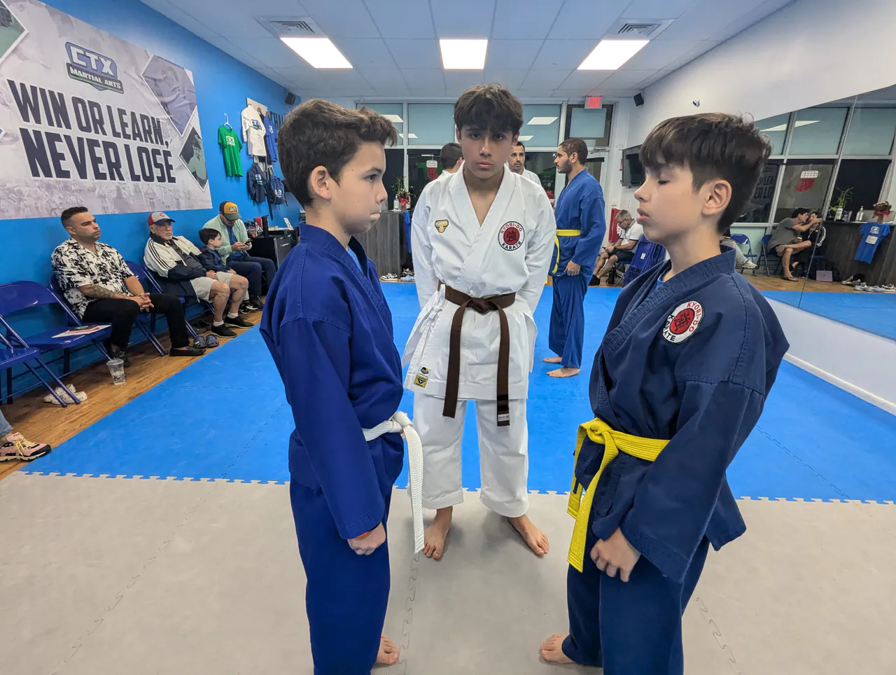 Instructor guiding two kids through a distance and boundary exercise on the mat