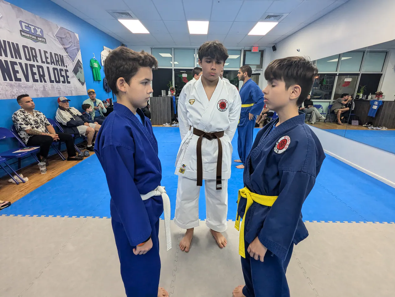 Instructor watching two kids practice keeping a safe distance during a self-defense drill