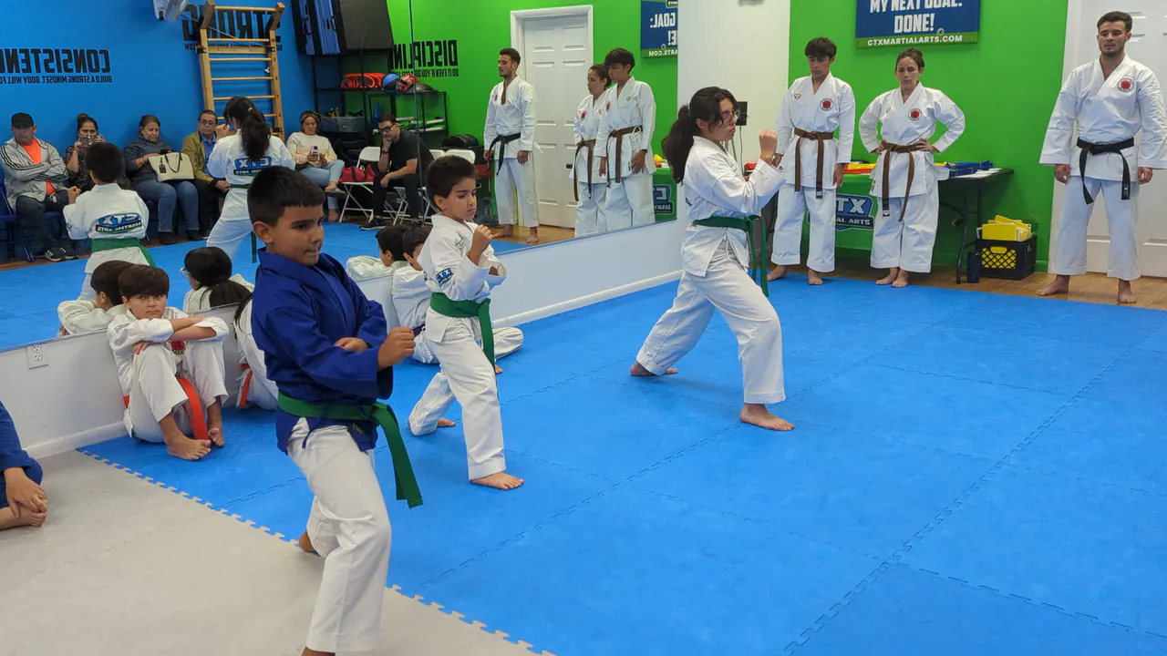 Several instructors supervising kids during a karate drill