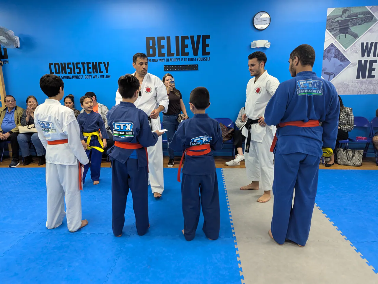 Karate instructors talking with a small group of youth students