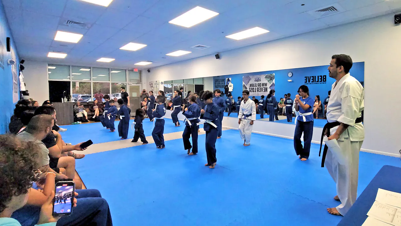 Parents watching from the side as kids practice in a martial arts class