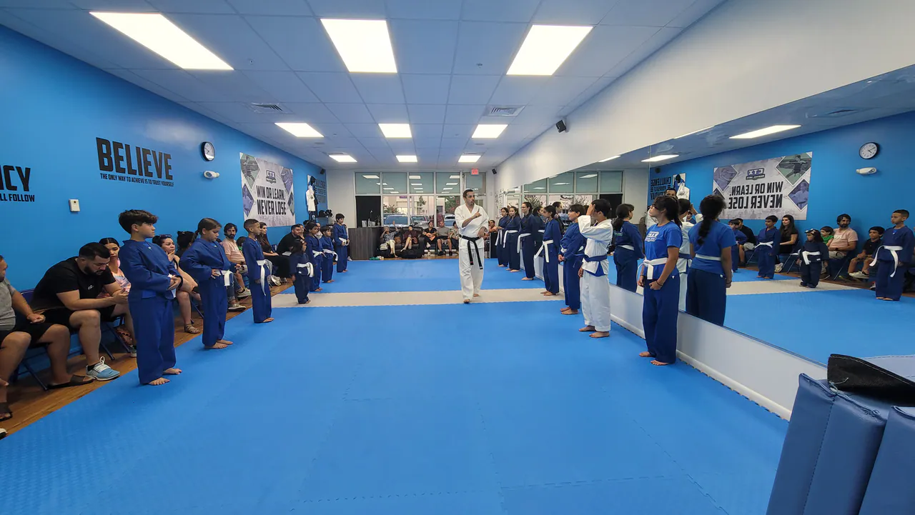 Organized kids karate class with students spaced apart along the mat